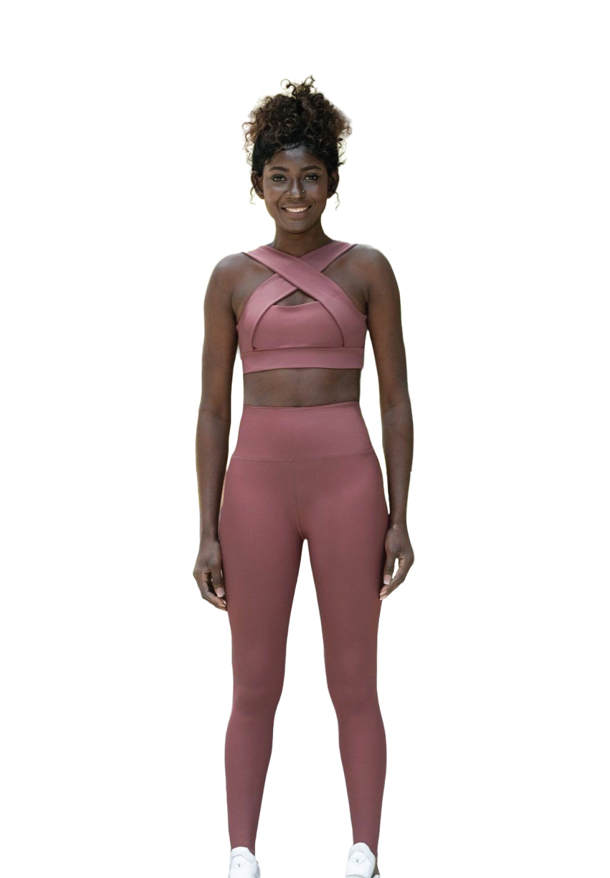 Eine Frau lächelt in Lisminas Crisscross-Top und 1095 High Waist Leggings in Dunkelrosé.
